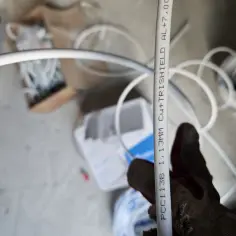 Rękawica trzyma biały kabel antenowy z oznaczeniami. Czy kabel antenowy ma znaczenie? Tak, jakość wpływa na sygnał.
