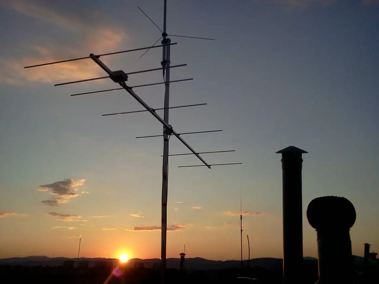 Antena kierunkowa UHF na tle zachodzącego słońca.